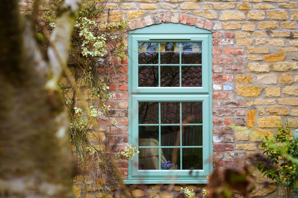 Chartwell Green PVCu casement window installed in a traditional stone home by Abbey Glass