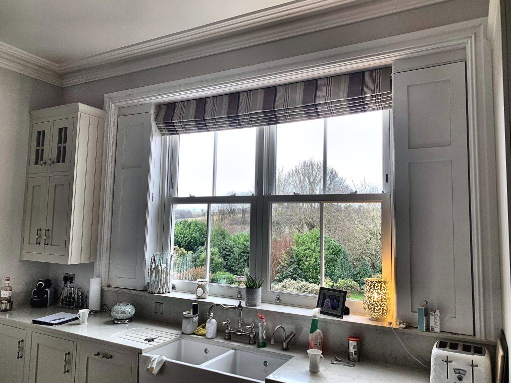 White sliding sash window overlooking garden view from kitchen sink