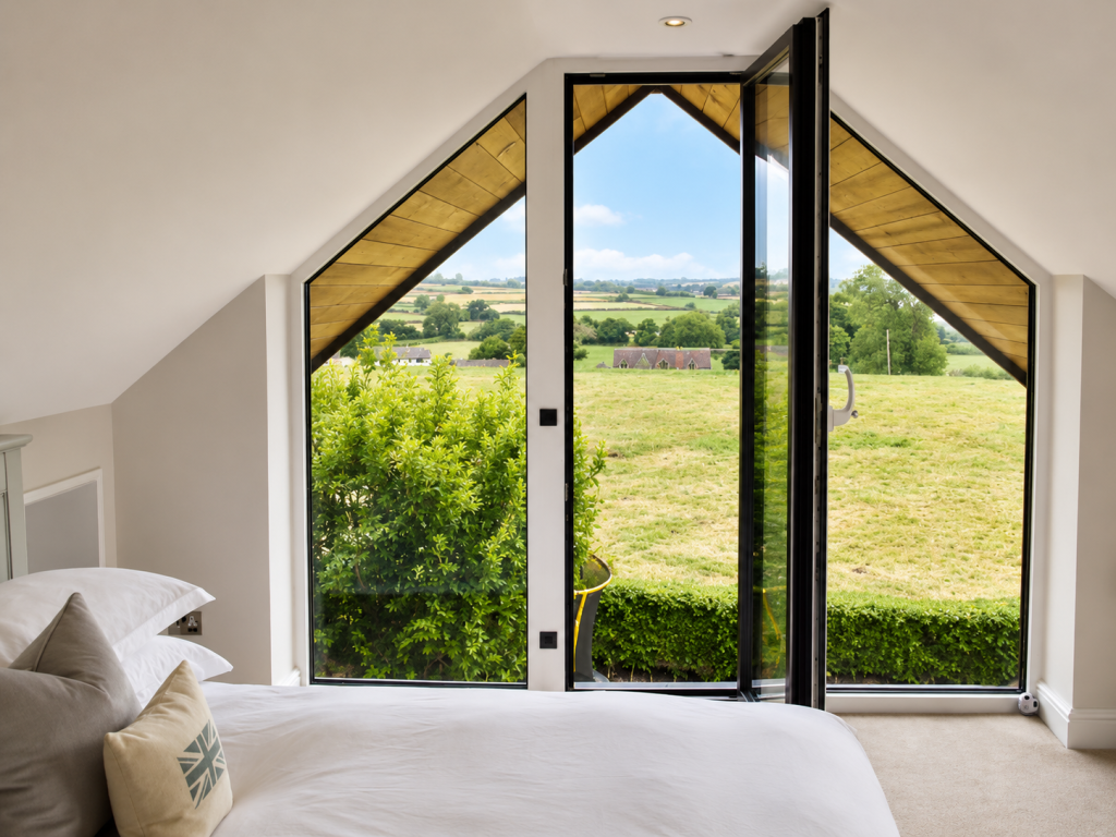 Bespoke anthracite grey aluminium apex windows fitted in a bedroom with countryside views in Derbyshire