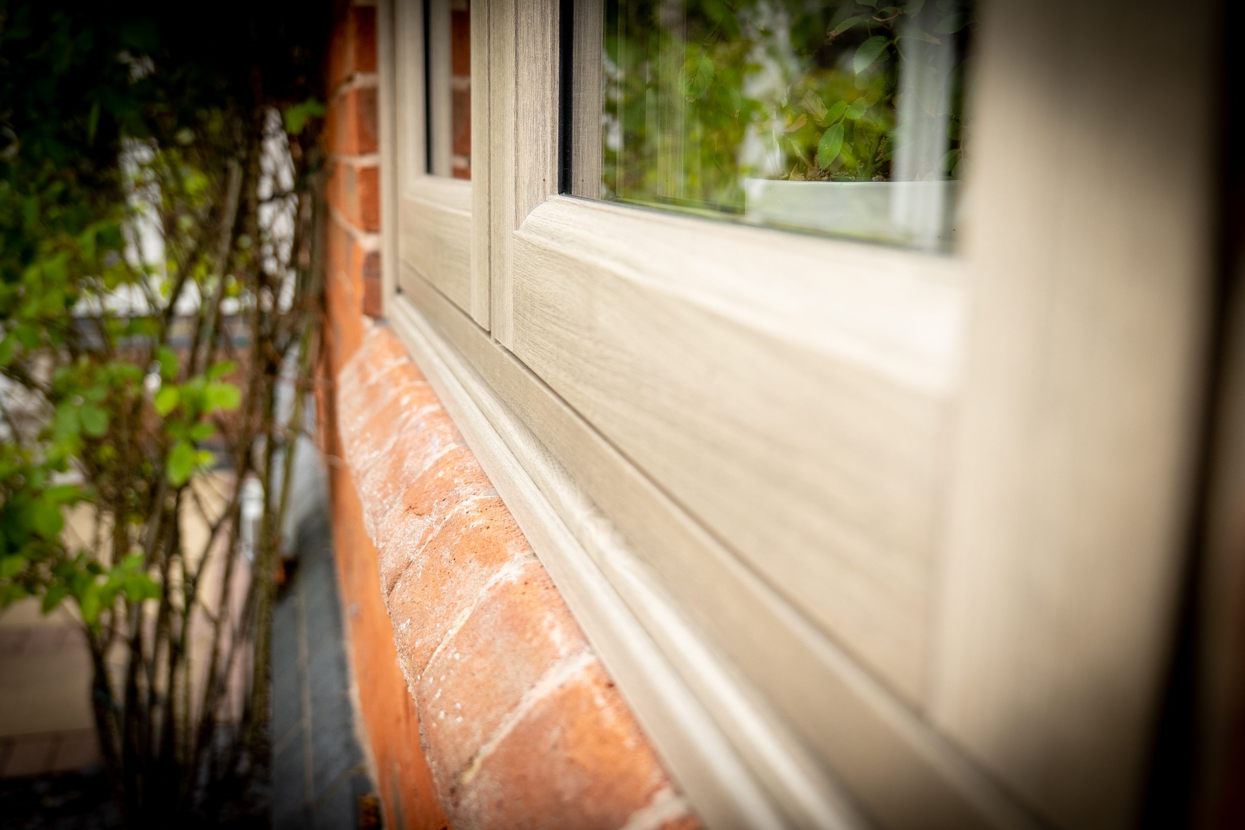 Anteak woodgrain flush fit PVCu window frame detail on a brick home in Derbyshire