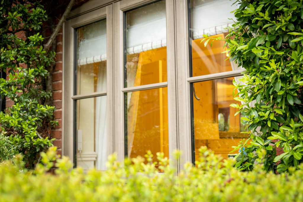 Anteak woodgrain flush fit PVCu casement windows on a traditional brick home in Derby