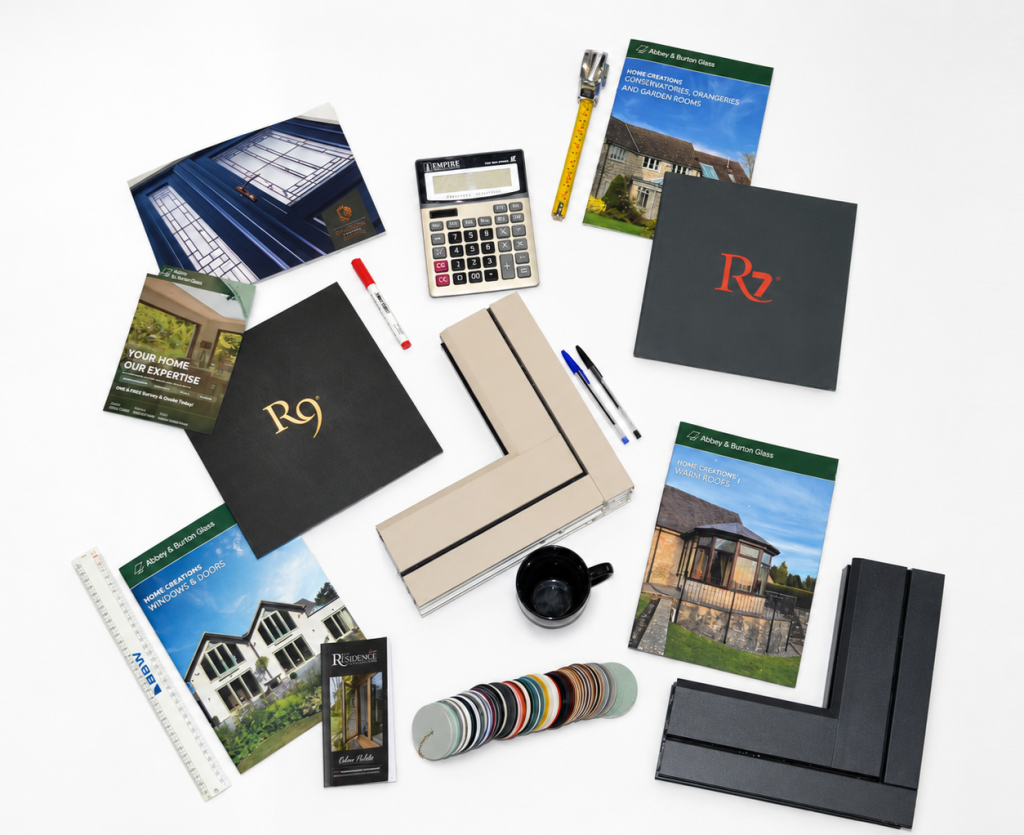 Abbey & Burton Glass brochures, window frame samples and home improvement product literature displayed on a table.