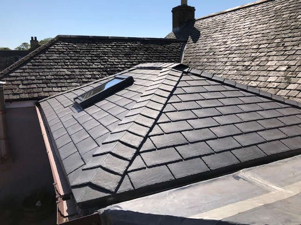 Warm tiled conservatory roof with lightweight slate-effect tiles, integrated roof windows and a hipped design, providing a stylish, energy-efficient replacement roof for a conservatory.