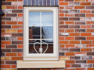 Cream PVCu casement window with Georgian bars installed on a modern brick home